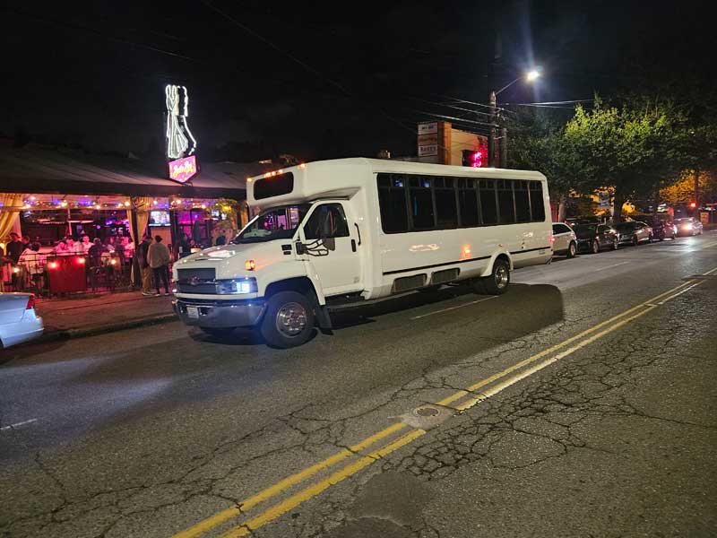 Club Eleven white 30-passenger party bus exterior photographed at night in Seattle