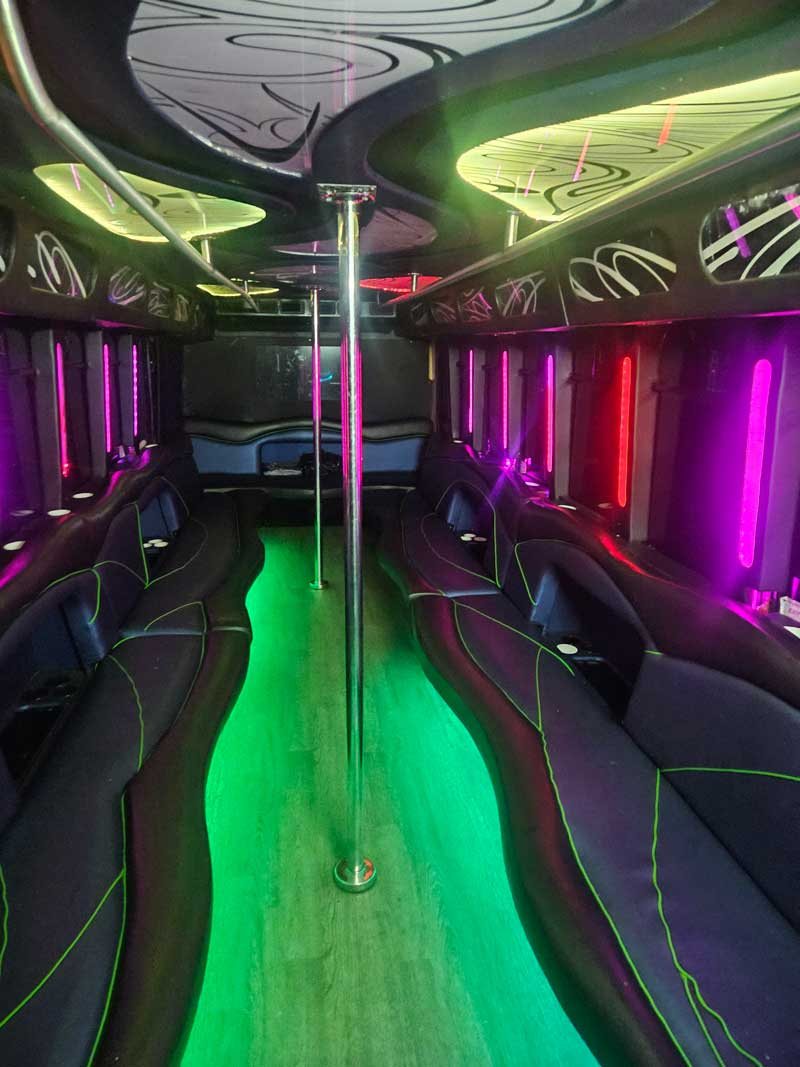 Club Eleven party bus interior with custom swirl ceiling, multi-color LED zone lighting, and dance pole