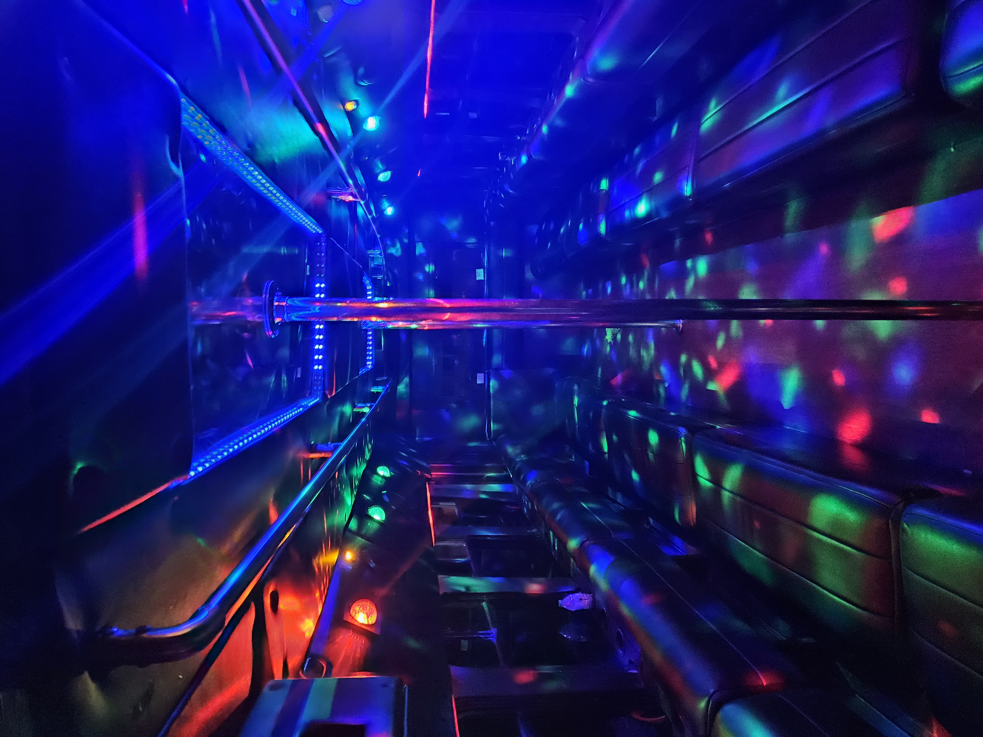 The Encore party bus interior with ceiling disco ball, blue LED lighting, and black leather seats